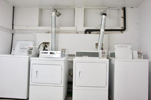 Zimmer mit 3 weißen Waschmaschinen und Kühlschränken in der Unterkunft NEW Stunning Large Gorgeous Space Downtown Parking Coffee in Moose Jaw