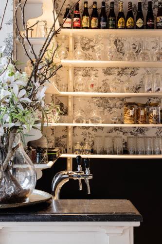 a kitchen with a sink and a shelf with glasses at Hotel Ter Brughe by CW Hotel Collection in Bruges