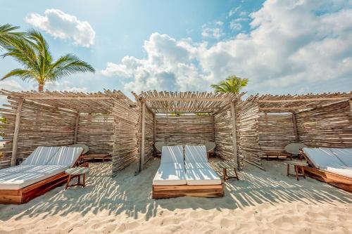 a resort with two beds and palm trees on the beach at Resorts World Bimini in Alice Town