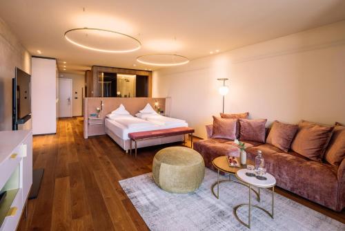 a living room with a couch and a bed at Hotel Hohenwart in Schenna