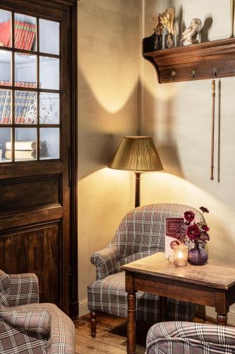 a living room with a chair and a table with a lamp at Hotel Ter Brughe by CW Hotel Collection in Bruges