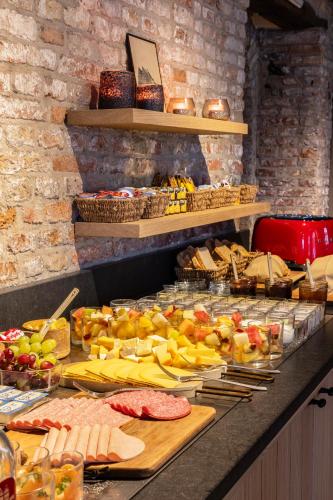 a buffet with many different types of food on a counter at Hotel Ter Brughe by CW Hotel Collection in Bruges