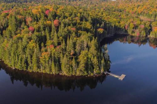 an island in the middle of a body of water at Les Refuges Perchés Mont-Tremblant in Saint-Faustin
