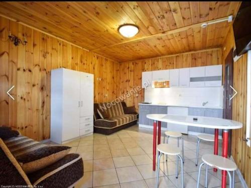 eine Küche mit einem Tisch und Stühlen im Zimmer in der Unterkunft Olimp Resort in Sarbinowo