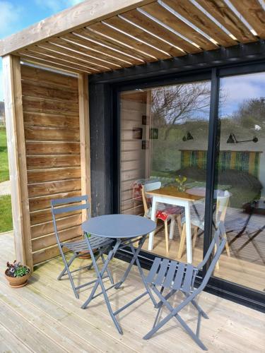 un patio avec une table et des chaises sur une terrasse dans l'établissement Au Dolmen de Kerhus 