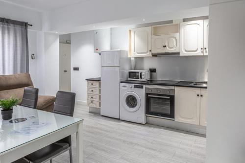 a kitchen with white appliances and a table in a room at ACC Vergara opción de Parking in Jaén