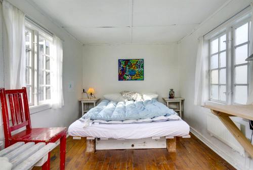 ein Schlafzimmer mit einem Bett in einem Zimmer mit Fenstern in der Unterkunft Idyll Summer house in Hornbæk in Hornbæk