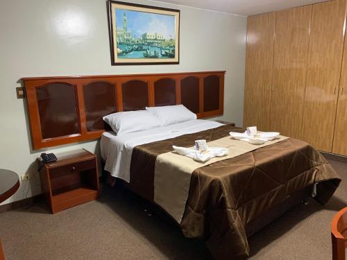 利馬的住宿－Grand Hotel Betsy，酒店客房,配有一张大床,上面有两个盘子