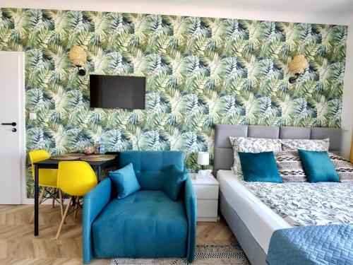 a bedroom with a blue bed and a yellow chair at Olivia Apartments - Słoneczny apartament w centrum Warszawy, Plac Unii Lubelskiej, Łazienki Królewskie, Pole Mokotowskie - 24h check-in in Warsaw