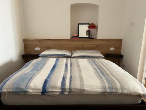 uma cama com um edredão listrado num quarto em Hilaris em Putignano