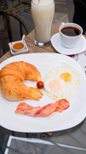 a plate of breakfast food with an egg and bacon at Casa Colonial Quito in Quito