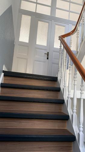 a stairway with a white door and white stairs at Ombak House im Bergischen in Burscheid