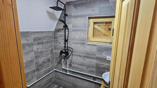 a shower in a bathroom with a tiled wall at Etno Villas Tara&Petra in Žabljak