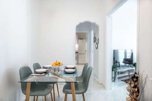 a dining room with a glass table and green chairs at Charmant in Athens
