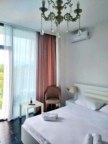 um quarto com uma cama, uma cadeira e uma janela em New House Kobuleti em Kobuleti