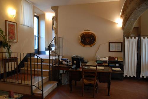 a room with a desk and a table with a computer at Hotel Scilla in Sovana