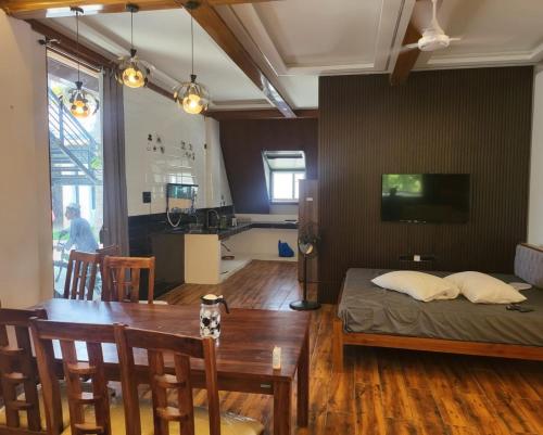 Habitación con mesa, cama y cocina. en Moon Light Resorts, en Ammāpettai