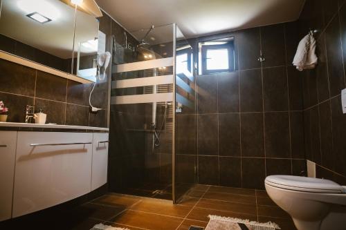 a bathroom with a shower and a toilet at Bellacya Resort & Spa in Sovata