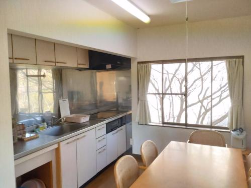 a kitchen with white cabinets and a table with chairs at Tenten Go Shibukawa - Vacation STAY 41129v in Ono