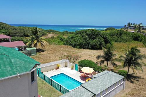 an overhead view of a swimming pool and the ocean at Lailamar Villa, Ocean view & Pool - Ground Floor in Saint Philip