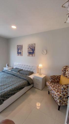 1 dormitorio con 1 cama y 1 silla en عنوان التميز غرفتين نوم بدخول ذاتي, en Dammam