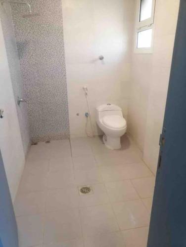 baño con aseo blanco en una habitación en عنوان التميز غرفتين نوم بدخول ذاتي, en Dammam