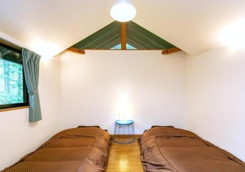 a bedroom with two beds and a table in it at Farm Inn Neba - Vacation STAY 46693v in Urugi