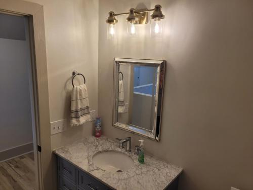 a bathroom with a sink and a mirror at The Hamilton House Loft in Omaha