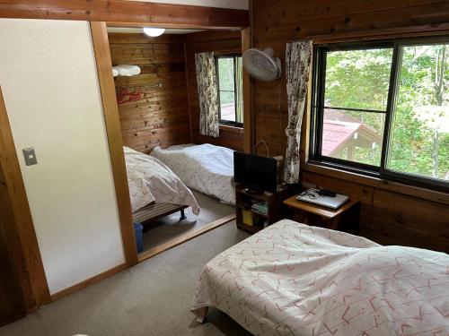Zao Pension Aramiya - Vacation STAY 40314v في Kaminoyama: غرفة نوم بسريرين ونافذة