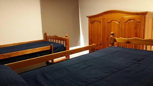 2 camas en un dormitorio con muebles de madera en Cruz de Ferreira en Palas de Rei 