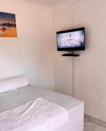 a room with a flat screen tv on a white wall at Comfort Guesthouse in Windhoek