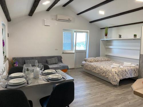 een woonkamer met een tafel en een bed bij Apartma Vista Baredi in Izola