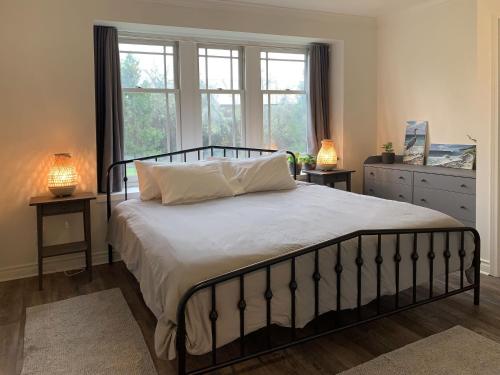 een slaapkamer met een bed met 2 lampen en een raam bij Vashon Inn in Vashon