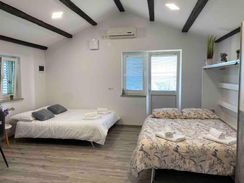 een slaapkamer met twee bedden en een raam bij Apartma Vista Baredi in Izola