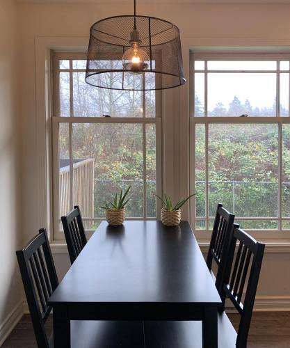 een zwarte eettafel met stoelen en een kroonluchter bij Vashon Inn in Vashon