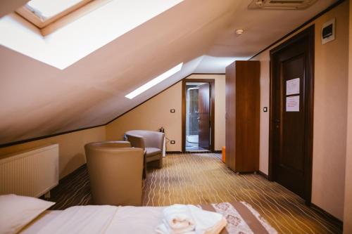 une chambre d'hôtel avec un lit et une lucarne dans l'établissement Bellacya Resort & Spa, à Sovata