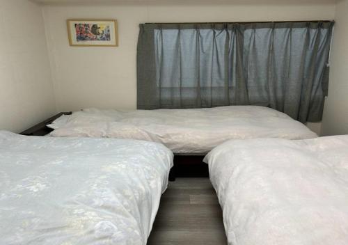 two twin beds in a room with a window at Ota Apartment - Vacation STAY 16060 in Otaru