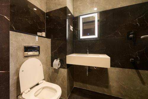a bathroom with a toilet and a sink at Hotel Merrytale in Kurinjippādi