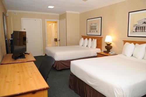 um quarto de hotel com duas camas e uma televisão em Civic Center Motor Inn em São Francisco