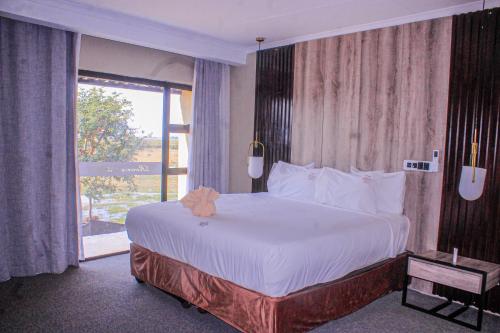 a bedroom with a large bed and a large window at Riverfront Resort and Camping in Shakawe