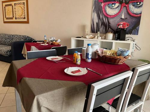 a table with a red table cloth on top of it at B&B PIAZZA KOLBE in Acquaviva delle Fonti