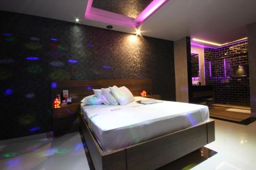 a bedroom with a bed in a room with purple lights at Motel Deslize Limeira 2 in Limeira