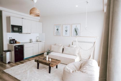a white living room with a couch and a table at Edera Spa in Rueil-Malmaison