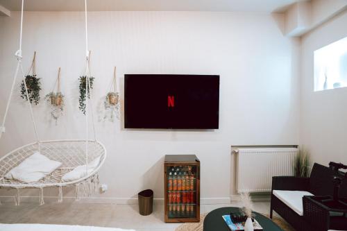 a living room with a tv hanging on the wall at Edera Spa in Rueil-Malmaison