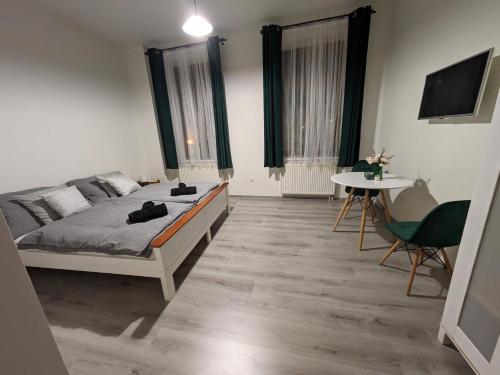 a bedroom with a bed and a table and a tv at Penzion Grand Nymburk in Nymburk