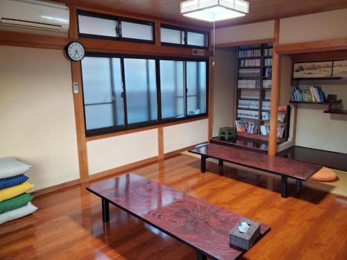 京丹後的住宿－Kotohi - Vacation STAY 16047，客厅设有两张桌子和墙上的时钟