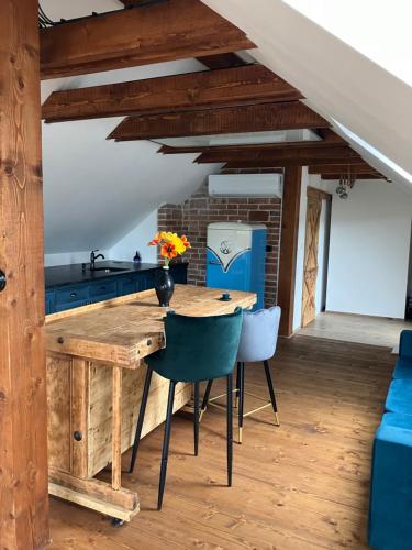a kitchen with a wooden table and blue chairs at Chalupa u Manišov in Laskár