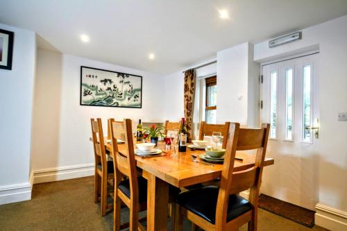 uma sala de jantar com uma mesa de madeira e cadeiras em Renovated 5 Bedroom Farmhouse in Picturesque Eskdale, Lake District em Eskdale