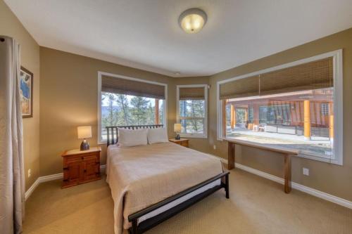 a bedroom with a bed and a large window at Marble Canyon in Fairmont Hot Springs