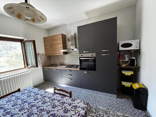 a small kitchen with a stove and a refrigerator at La lavanda in Controguerra